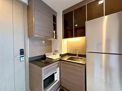 a small kitchen with a refrigerator and a sink at 1BR Luxury Condo 50m to Thonglor BTS station in Bangkok