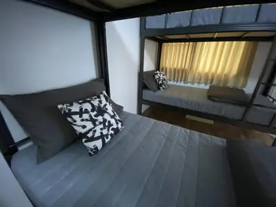 a small bedroom with a bed and a window at Doodle Lodge Bangkok in Bangkok