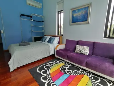 a living room with a purple couch and a bed at AP HOUSE in Bangkok