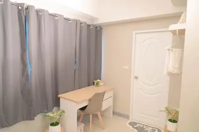 a desk in a room with gray curtains at BnB98 Silom Hotel in Bangkok