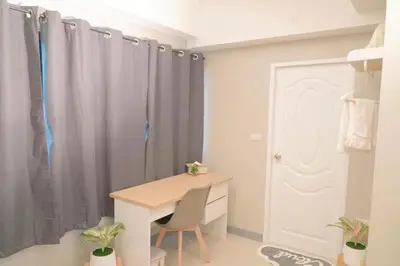 a room with a desk and a door with curtains at BnB98 Silom Hotel in Bangkok