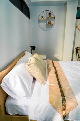 a bed with white sheets and pillows in a room at BnB98 Silom Hotel in Bangkok
