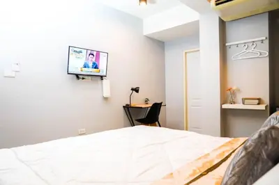 a bedroom with a bed with a tv on the wall at BnB98 Silom Hotel in Bangkok