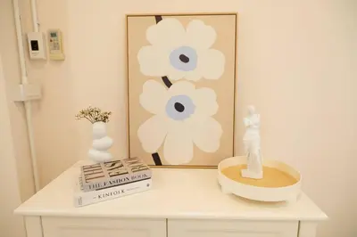 a white table with a book and a picture of flowers at 2BR minimal mu-ji style 130SQM ~ in Makkasan
