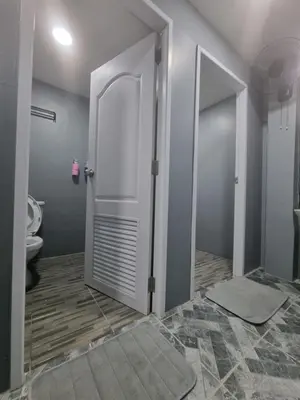 a bathroom with a white door and a toilet at Met A Space Pod @Phrom Phong in Bangkok