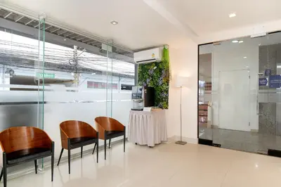 a room with chairs and a table and a kitchen at Synsiri Lat Phrao 83 in Ban Zong Katiam