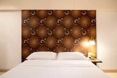 a bedroom with a bed and a black and gold wallpaper at Synsiri Lat Phrao 83 in Ban Zong Katiam