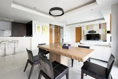 a kitchen and dining room with a wooden table and chairs at M Estate 2BR Private Residence, 300m to BTS Chit Lom in Bangkok