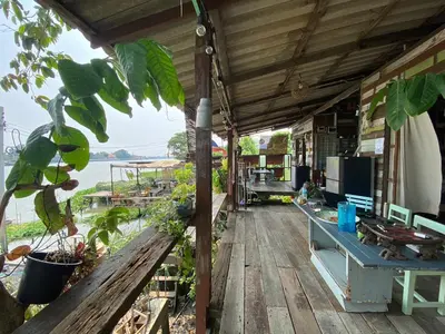 a porch of a house with a view of the water at Baan GoLite Ko Kret - บ้านโกไล้เกาะเกร็ด in Nonthaburi