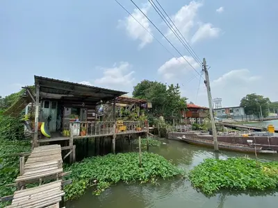 a house on a river next to a body of water at Baan GoLite Ko Kret - บ้านโกไล้เกาะเกร็ด in Nonthaburi