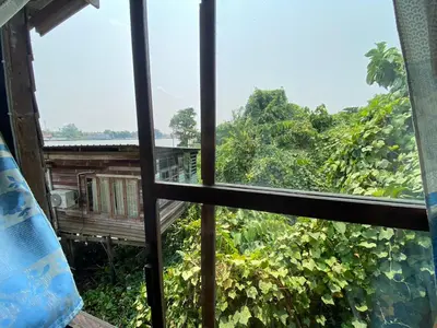a view out of a window looking out into the forest at Baan GoLite Ko Kret - บ้านโกไล้เกาะเกร็ด in Nonthaburi