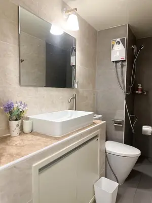 a bathroom with a white sink and a toilet at Happiness Sleep in Thung Si Kan