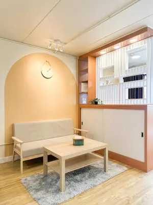 a living room with a couch and a table at Happiness Sleep in Thung Si Kan