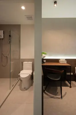 a bathroom with a toilet and a desk and a shower at C'HOUSE Bangkok in Pom Prap