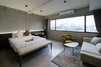 a hotel room with a bed and a couch at C'HOUSE Bangkok in Pom Prap
