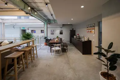 a restaurant with a table and chairs and a counter at C'HOUSE Bangkok in Pom Prap