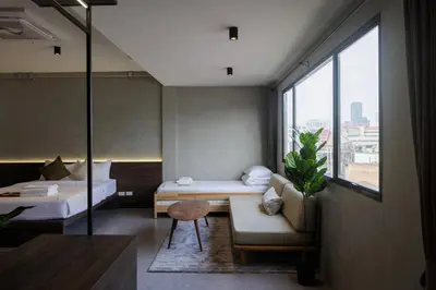 a room with a bed and a couch and a table at C'HOUSE Bangkok in Pom Prap