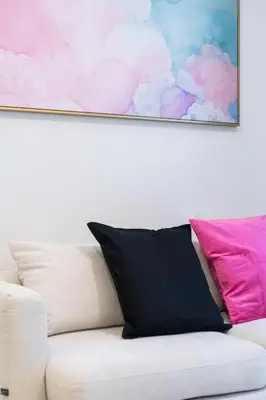 a white couch with two pillows and a painting on the wall at 1bed room bts thonglo SuperiorSpaApartment in Ban Chaliang Khok