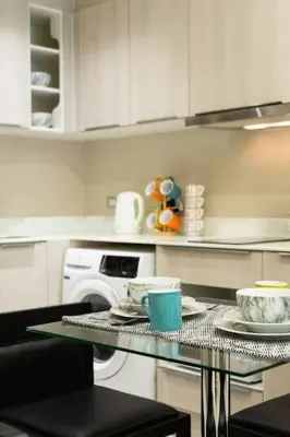 a kitchen with a table with cups and dishes on it at 1bed room bts thonglo SuperiorSpaApartment in Ban Chaliang Khok
