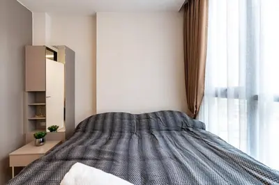 a bedroom with a bed and a window at 1bed room bts thonglo SuperiorSpaApartment in Ban Chaliang Khok