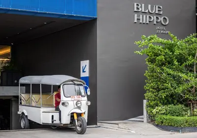 a small car parked in front of a building at Blue Hippo & Red Crocodile Hotel in Bangna