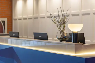 a reception desk with two laptops and a lamp at Blue Hippo & Red Crocodile Hotel in Bangna
