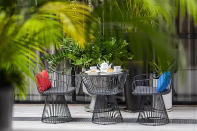 a group of three chairs with a table and plants at Blue Hippo & Red Crocodile Hotel in Bangna