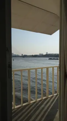 a room with a view of the water from a balcony at Riverfront house/Chao phraya river/Baan Rimphraya in Bangkok