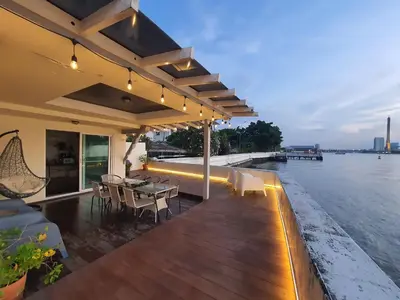 a house with a deck with a view of the water at Riverfront house/Chao phraya river/Baan Rimphraya in Bangkok