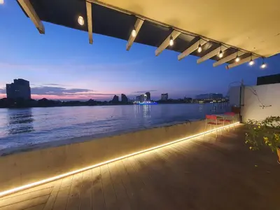 a view of the water from a beach with lights at Riverfront house/Chao phraya river/Baan Rimphraya in Bangkok